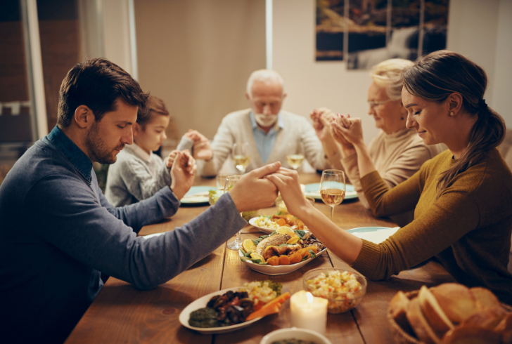 Family praying before healthy meal